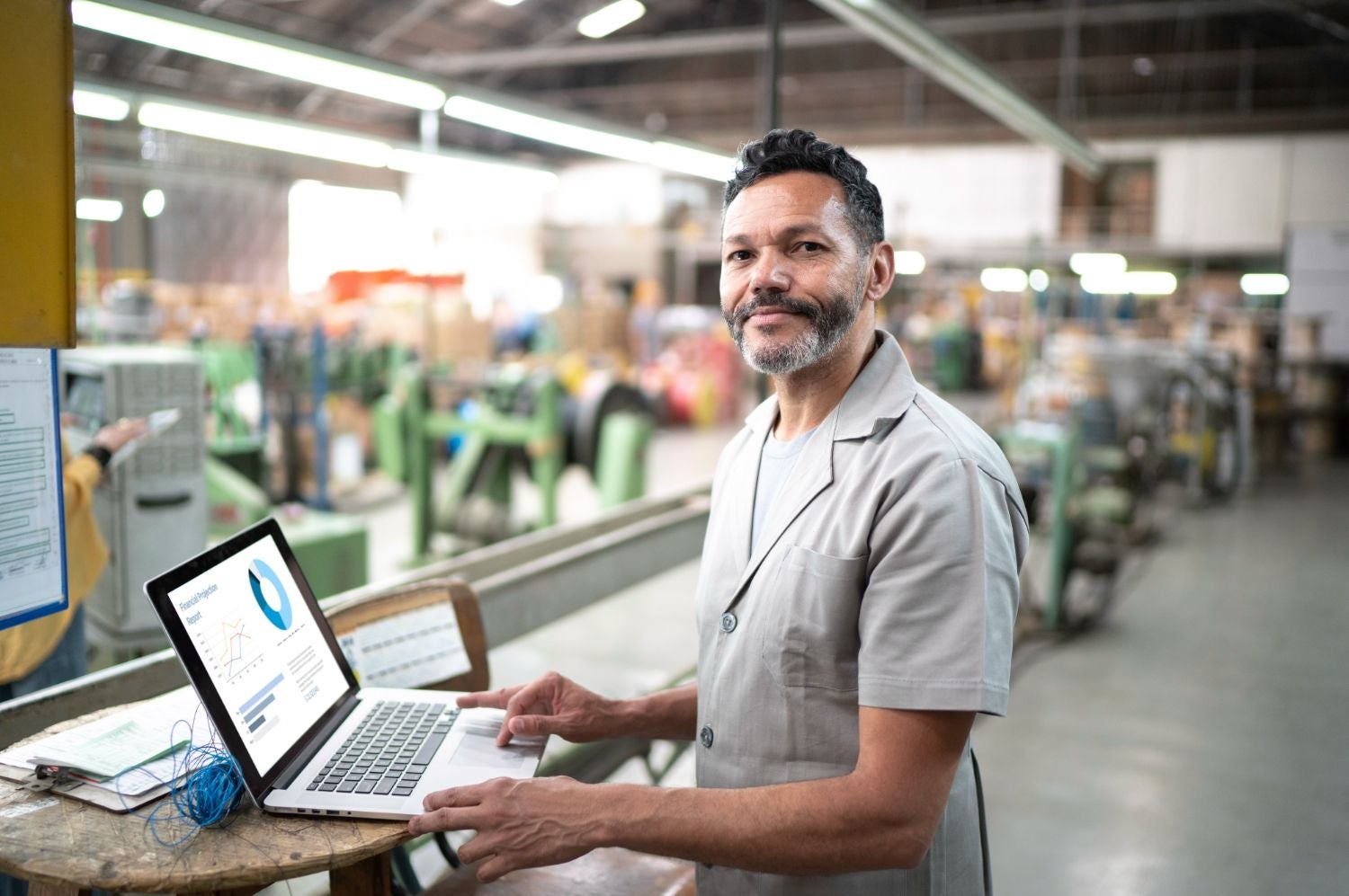 Smiling warehouse manager reviewing analytics on a computer