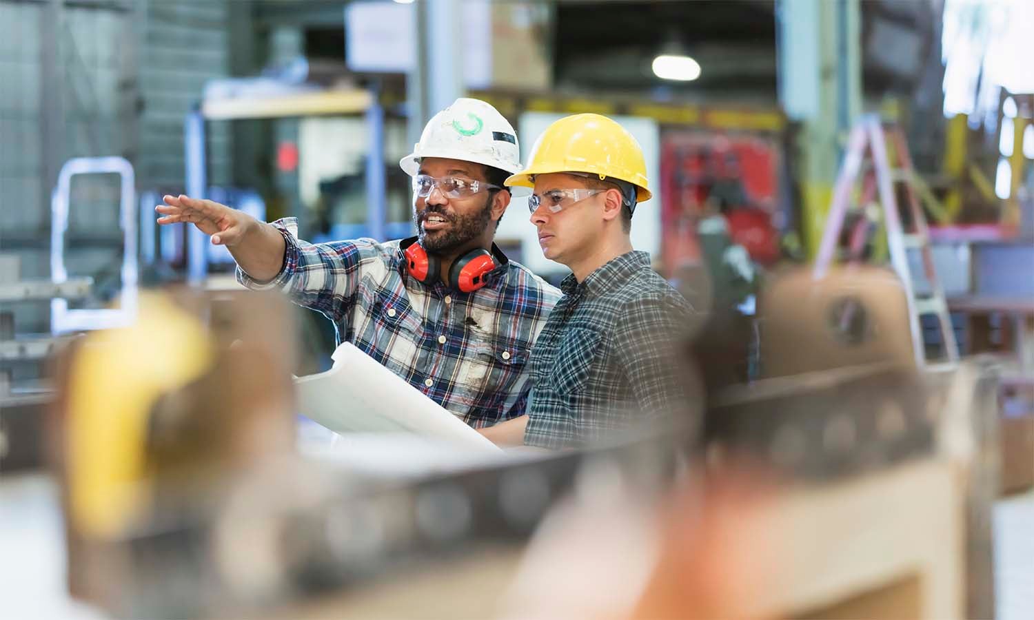 Two industrial employees talking in a factory setting