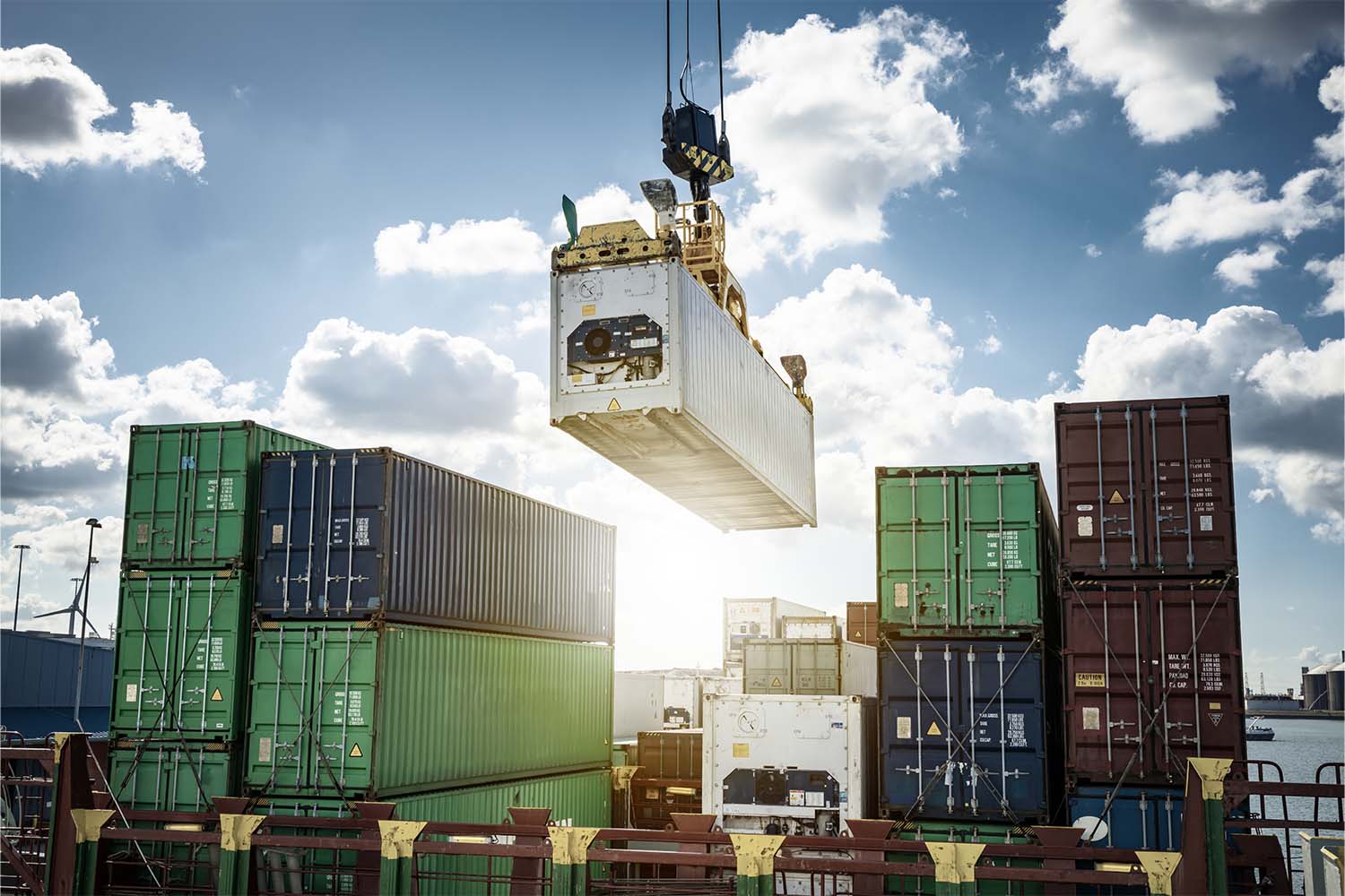 Sun shining through a loading dock as shipping containers are moved