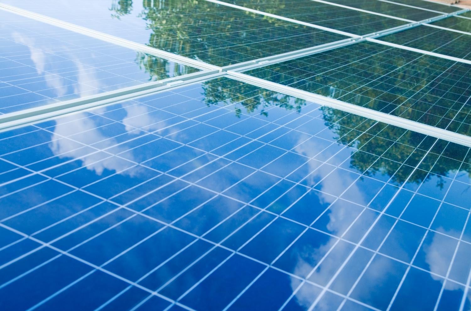 Trees and clouds reflected by solar panels