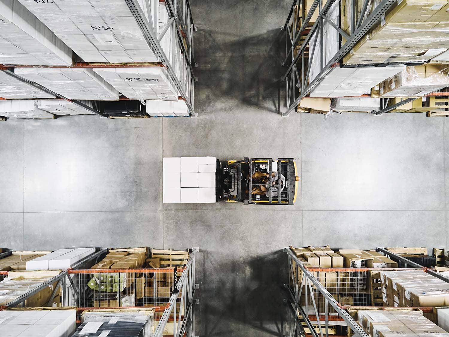 Overhead image of forklift moving through warehouse aisles