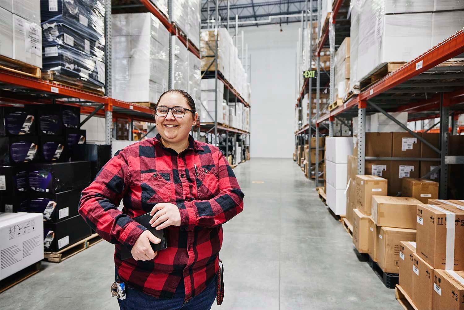 Smiling warehouse worker in a storage aisle