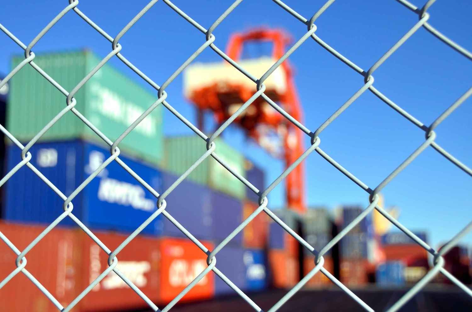 Chainlink fence with a cargo ship in the background