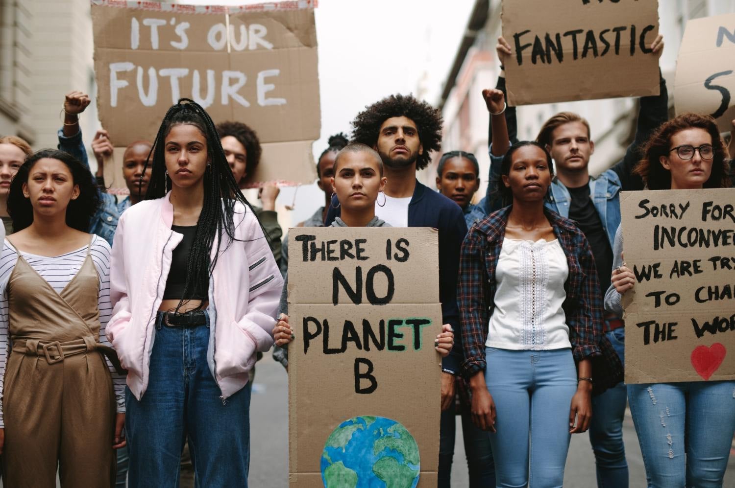 Young climate protestors holding signs