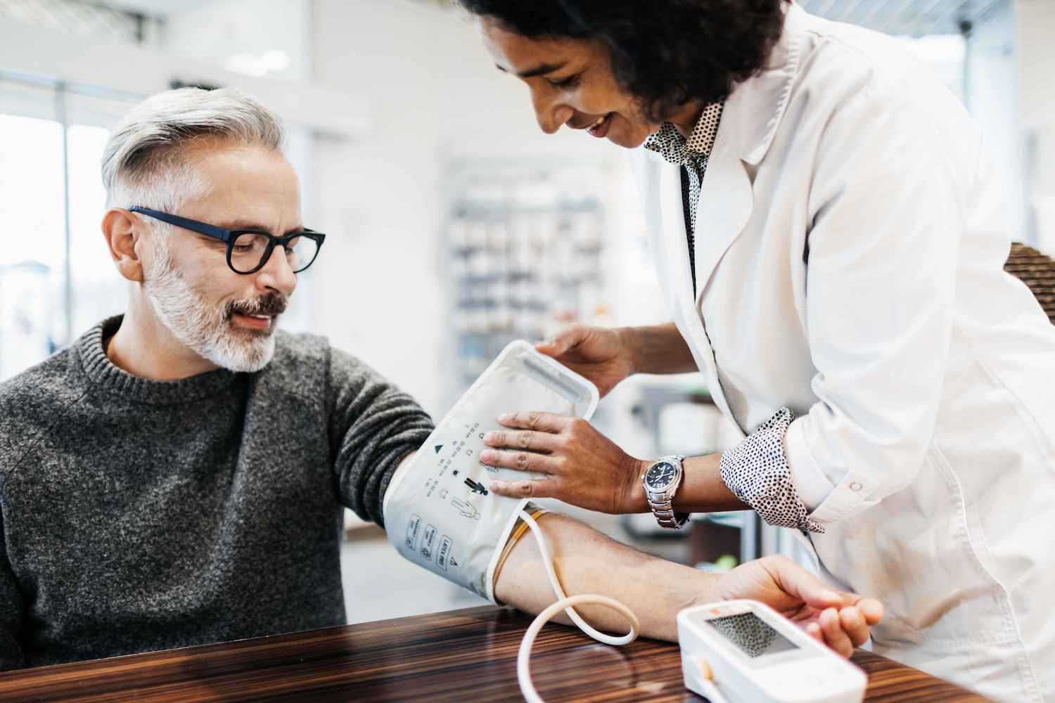 Medical worker taking an older man's blood pressure