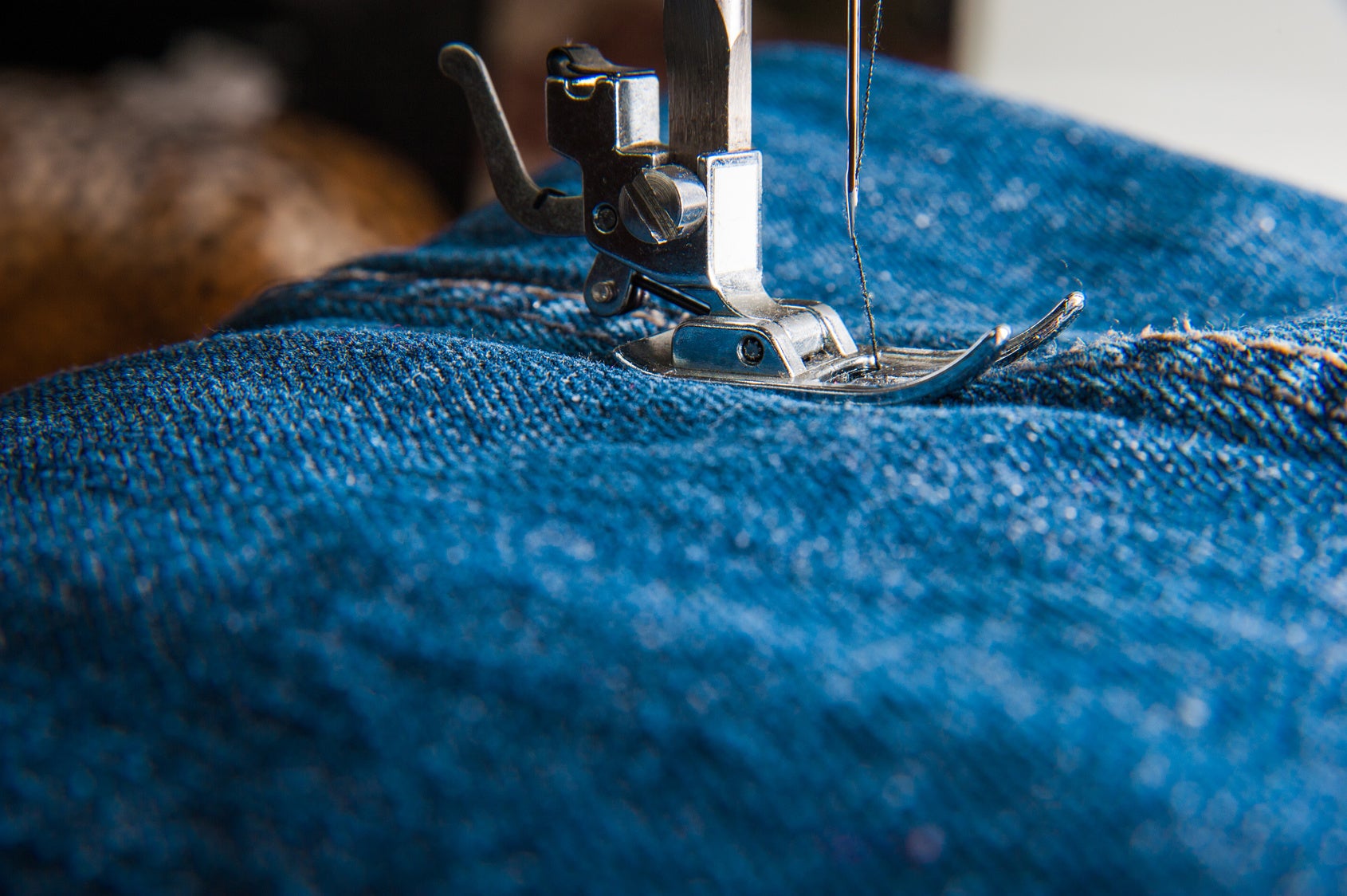 Close-up of a sewing machine working on jeans