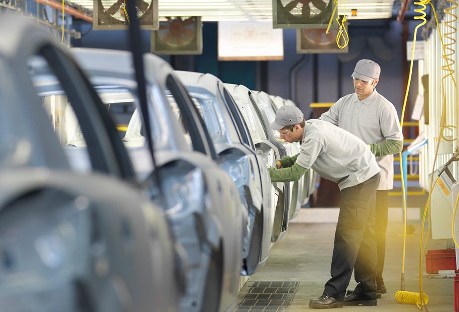 workers on an automotive assembly line.