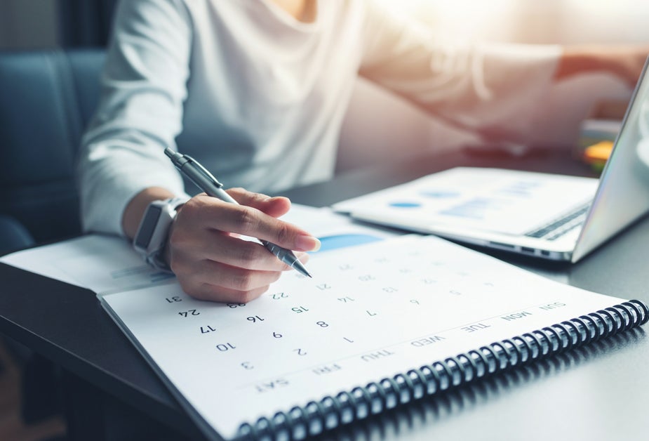 Manager planning their 2024 proactive compliance budget with a calendar in hand.