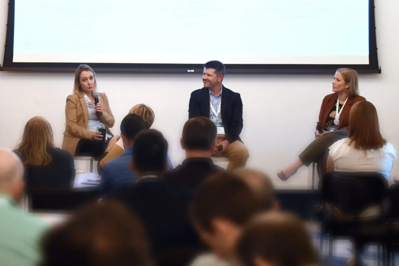 A conference with 3 Assent leaders speaking in front of a crowd